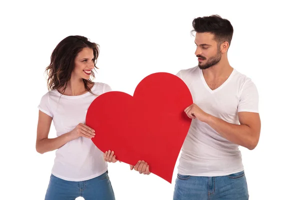 Homem feliz e mulher segurando um coração — Fotografia de Stock