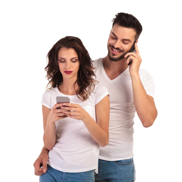 Casual man talking on phone and woman texting — Stock Photo, Image