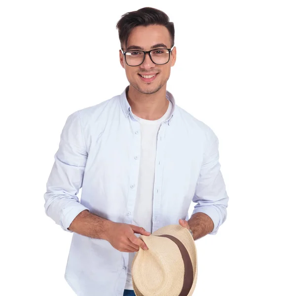 Smiling young casual man holding a hat — Stock Photo, Image