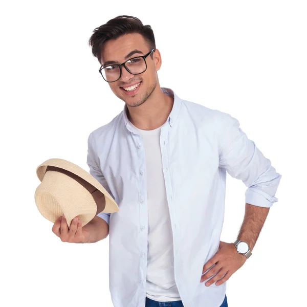 Felice giovane uomo casual tiene il cappello e sorride — Foto Stock