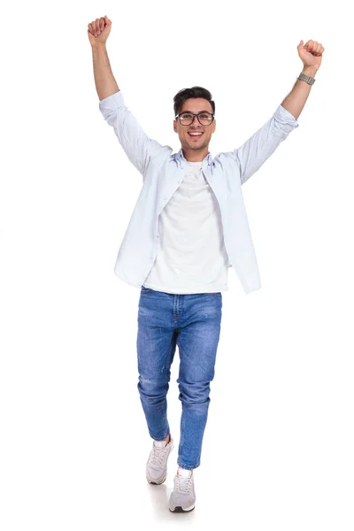 Casual man with hands in the air is walking — Stock Photo, Image