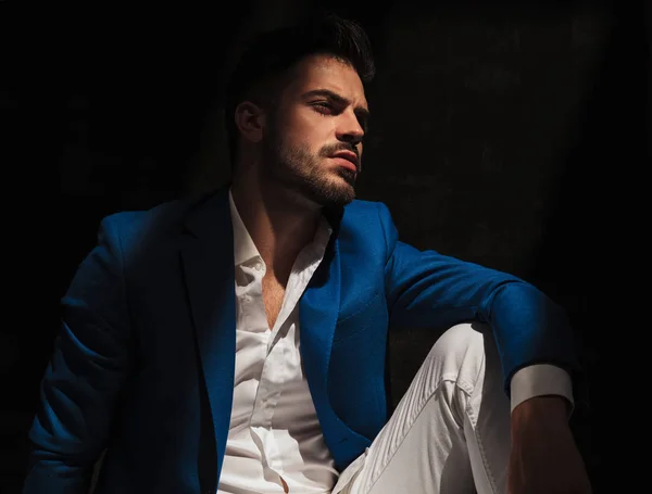Side view of a dramatic man sitting in studio — Stock Photo, Image