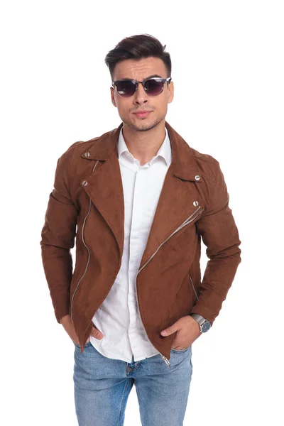 Человек в куртке и солнцезащитных очках, стоящий с руками в карманах — стоковое фото