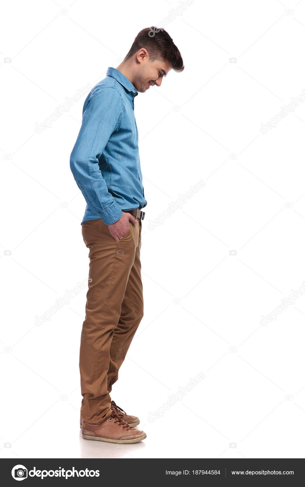 side view of stylish man in suit standing with hands in pockets and looking  away isolated on grey Stock Photo by LightFieldStudios