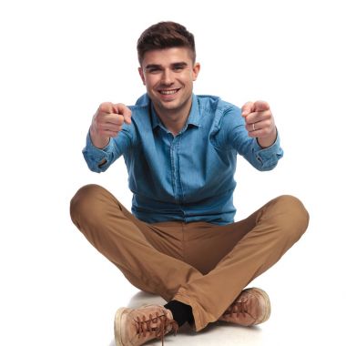 casual adam katta oturan parmakları işaret ediyor 