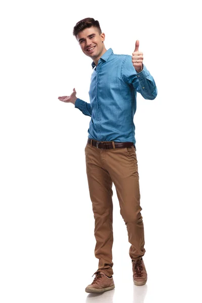 Laughing young casual man presenting and making ok sign — Stock Photo, Image