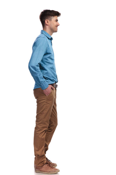 side view of a smiling casual man waiting in line 