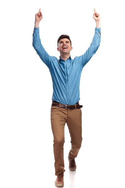 walking casual man celebrting success with hands in the air 