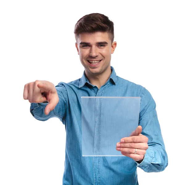 Ευτυχισμένος άνθρωπος casual κρατώντας διαφανή δισκίο δείχνει δάχτυλο — Φωτογραφία Αρχείου