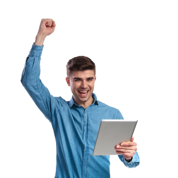 Young man holding tablet is celebrating success — Stock Photo, Image