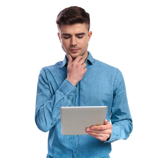 Joven lectura casual en una tableta está pensando — Foto de Stock