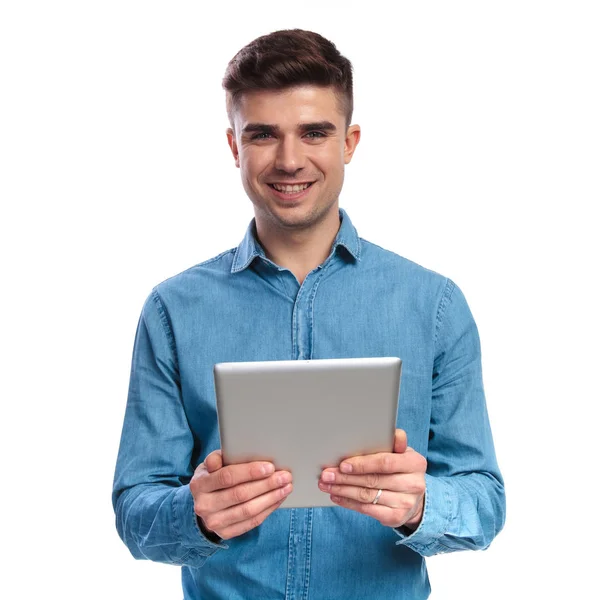 Sorrindo jovem casual homem segurando um tablet — Fotografia de Stock