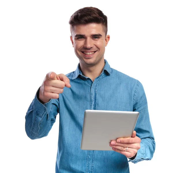 Усміхнений випадковий чоловік тримає планшет вказує палець — стокове фото