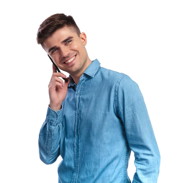 Uśmiechający się młody człowiek dorywczo rozmawia przez telefon wygląda odległości — Zdjęcie stockowe