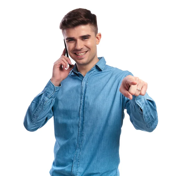 Sorrindo homem casual falando ao telefone está apontando dedo — Fotografia de Stock