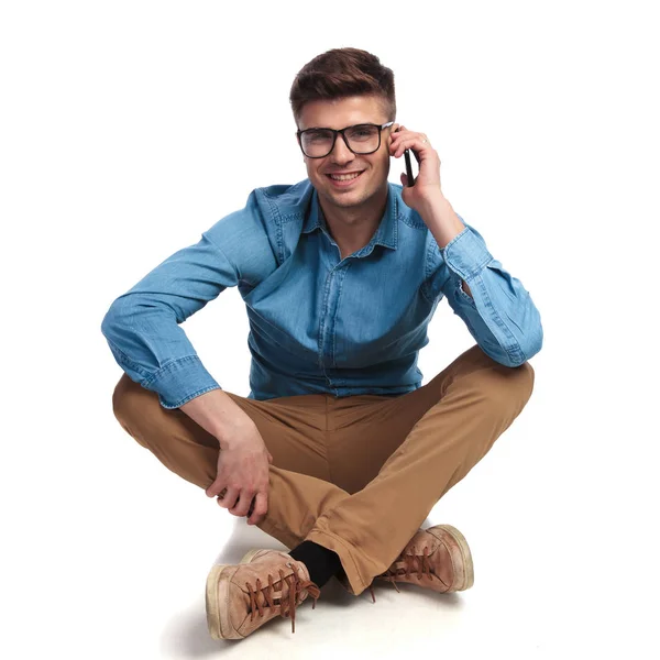 Casual man sits  and talks on the phone — Stock Photo, Image