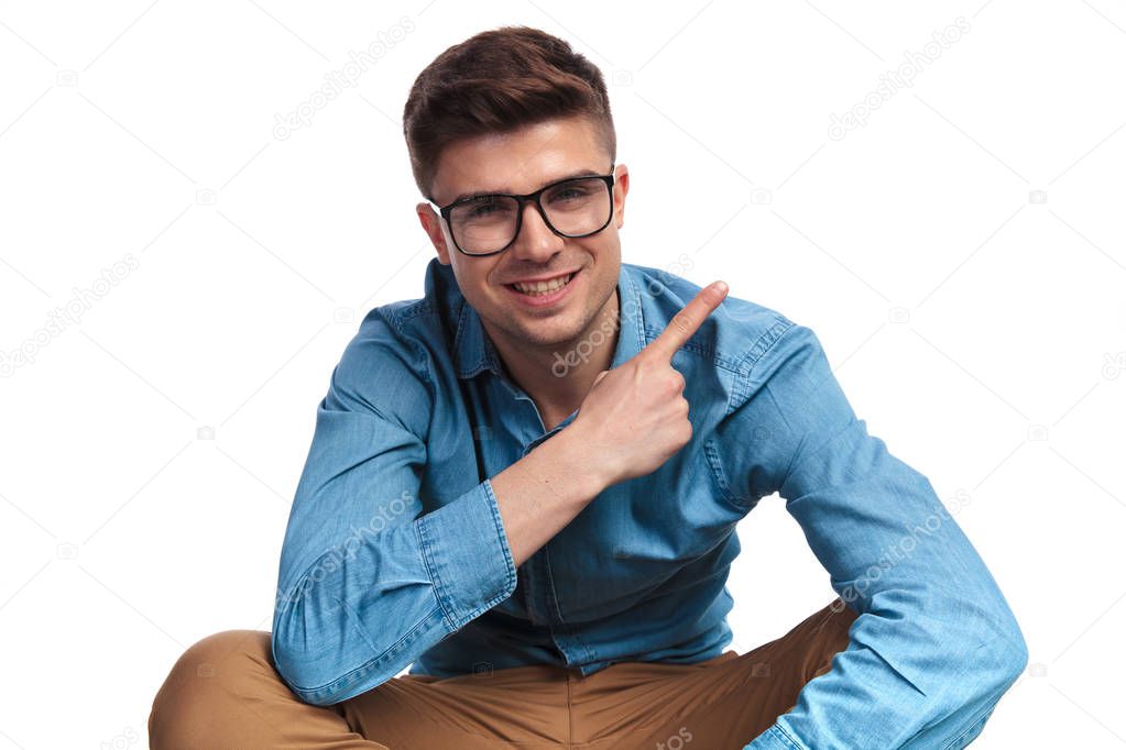 seated casual man pointing finger to side