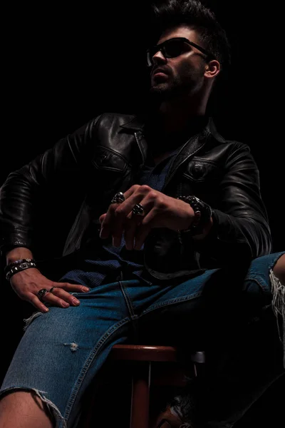 Fashion man wearing leather jacket and sunglasses looks to side — Stock Photo, Image