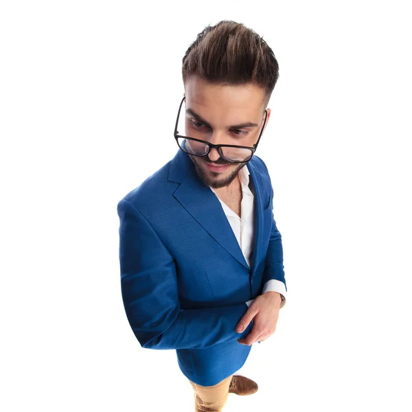 Casual man with hands folded looks over glasses to side — Stock Photo, Image