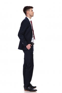 Elleri ceplerinde sırada bekleyen iş adamı