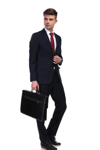 Business man looks to side while holding his briefcase — стоковое фото