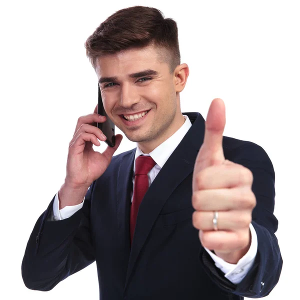 Взволнованный бизнесмен говорит по телефону и делает хороший знак — стоковое фото