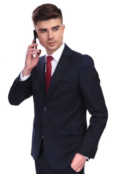 Relaxed businessman speaking on the phone looks to side — Stock Photo, Image
