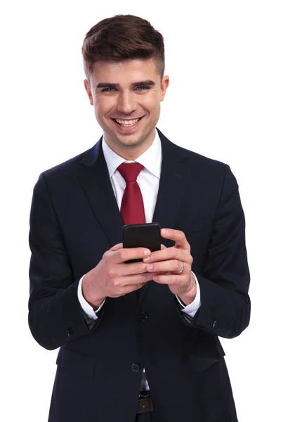 Happy businessman is writing a funny sms on the phone — Stock Photo, Image