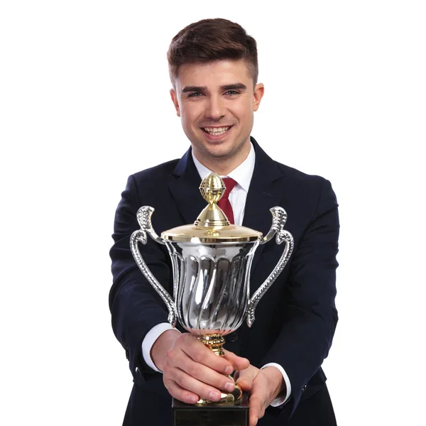 Feliz hombre de negocios que ofrece la copa ganadora — Foto de Stock