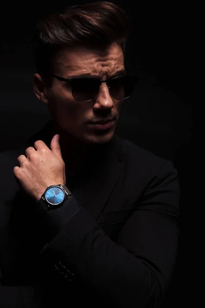 Moda mężczyzna pokazuje zegarek i wygląda na stronie — Zdjęcie stockowe