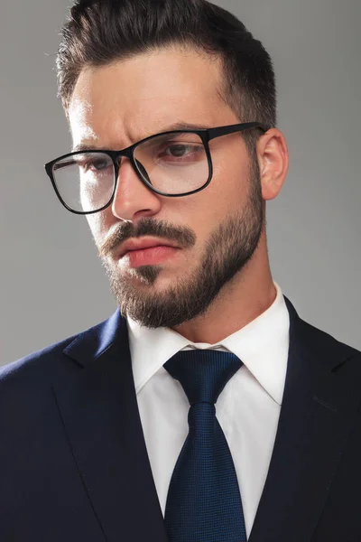 Attraktiver seriöser Geschäftsmann mit zur Seite blickender Brille — Stockfoto