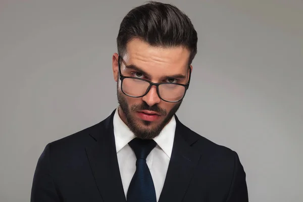 Porträt eines sinnlichen Geschäftsmannes, der über eine Brille blickt — Stockfoto