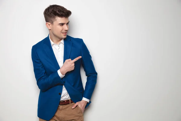 Standing smart casual man looking and pointing to side — Stock Photo, Image