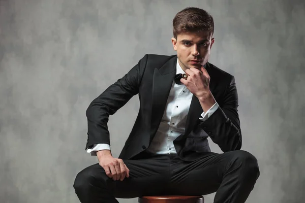 Pensive businessman in black tuxedo sitting on chair — Stock Photo, Image