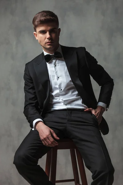 Homem de negócios descontraído vestido elegantemente sentado com a mão em punho — Fotografia de Stock