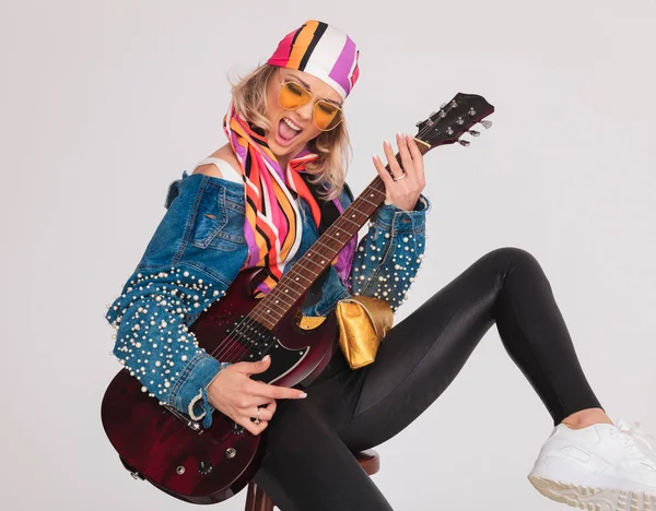 Σέξι γυναίκα με ανοιχτόχρωμα ρούχα, παίζοντας ηλεκτρική κιθάρα της — Φωτογραφία Αρχείου