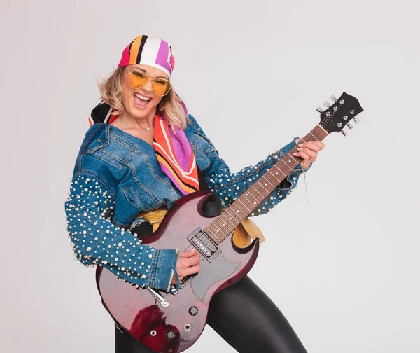 Glada kvinna med färgglad outfit tycker om att spela den elektriska gu — Stockfoto