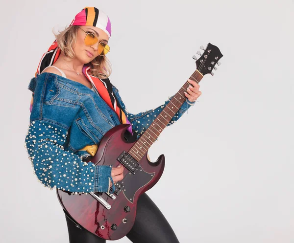 Mujer estrella de rock con traje colorido tocando la guitarra — Foto de Stock