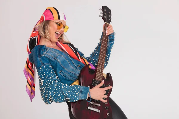 Mujer con ropa de color realizando un concierto de rock en la guitarra — Foto de Stock