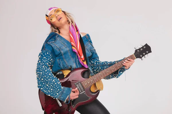 Smyslná žena s barevným šátkem hraje na elektrickou kytaru — Stock fotografie
