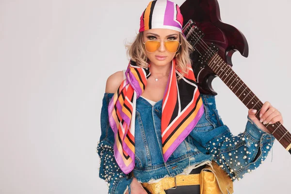 Porträtt av kvinna med färgglada kläder och gitarr på axel — Stockfoto