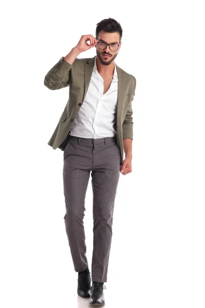 Slimme stijlvolle man met groene pak lopen tijdens de vaststelling van de bril — Stockfoto