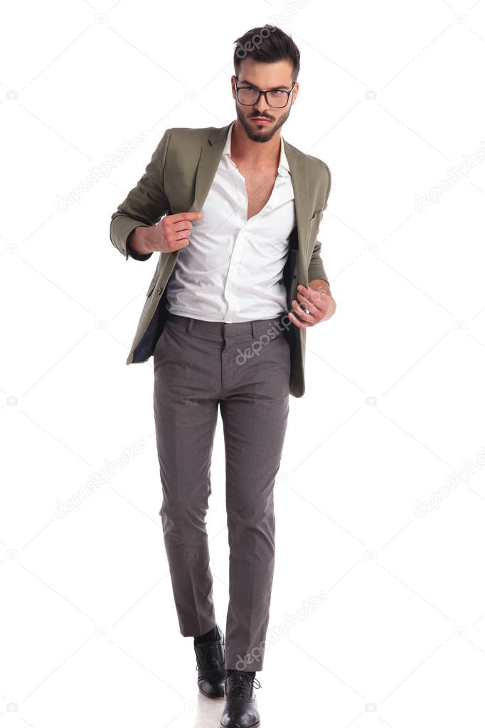 sexy elegant man with open collar and green suit walking 