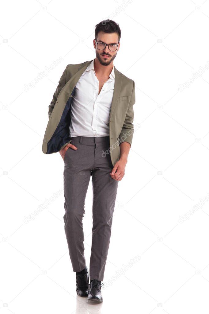 relaxed handsome man wearing a green suit stepping