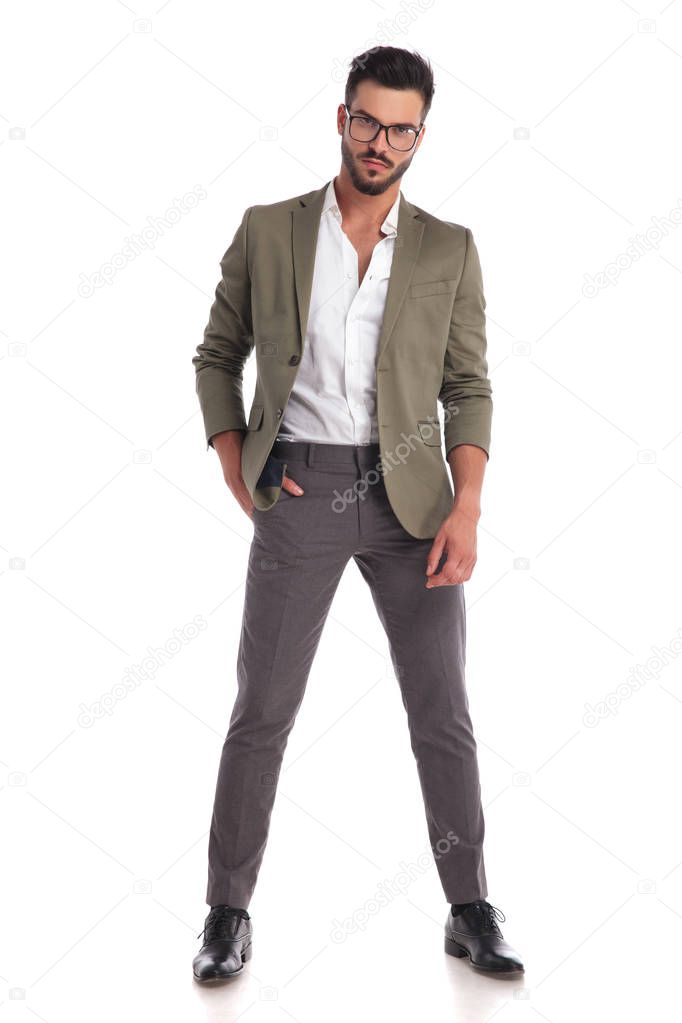 confident businessman with glasses standing with hand in pocket