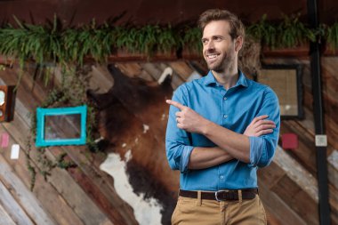 Neşeli sıradan bir adam yan tarafı gösteriyor ve gülüyor.