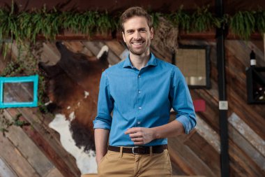 Neşeli adam elini cebinde tutuyor ve gülüyor.