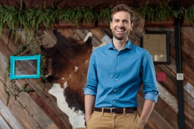 Elleri cebinde gülen keyifli sıradan bir adam.