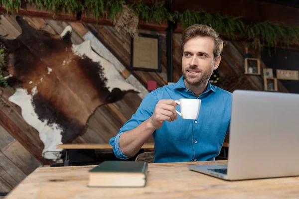Vrolijke casual man kijken weg en het drinken van zijn koffie — Stockfoto