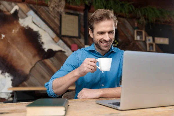 Radosny, swobodny człowiek czytający, śmiejący się i pijący kawę — Zdjęcie stockowe
